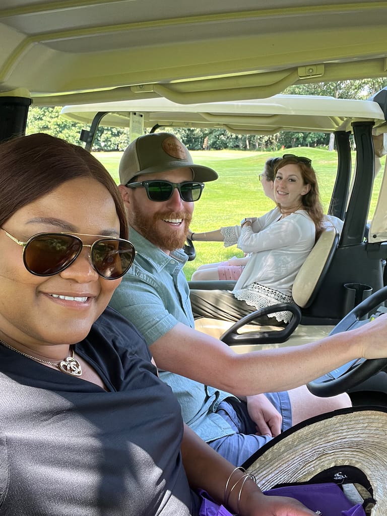 Triangle staff and participants ride in golf carts at our annual Golf Tournament.